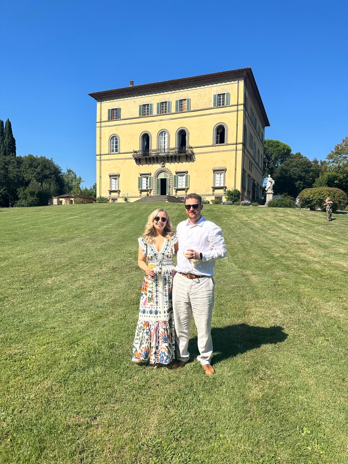 Zara and Alec on the lawn in front of a Tuscan villa